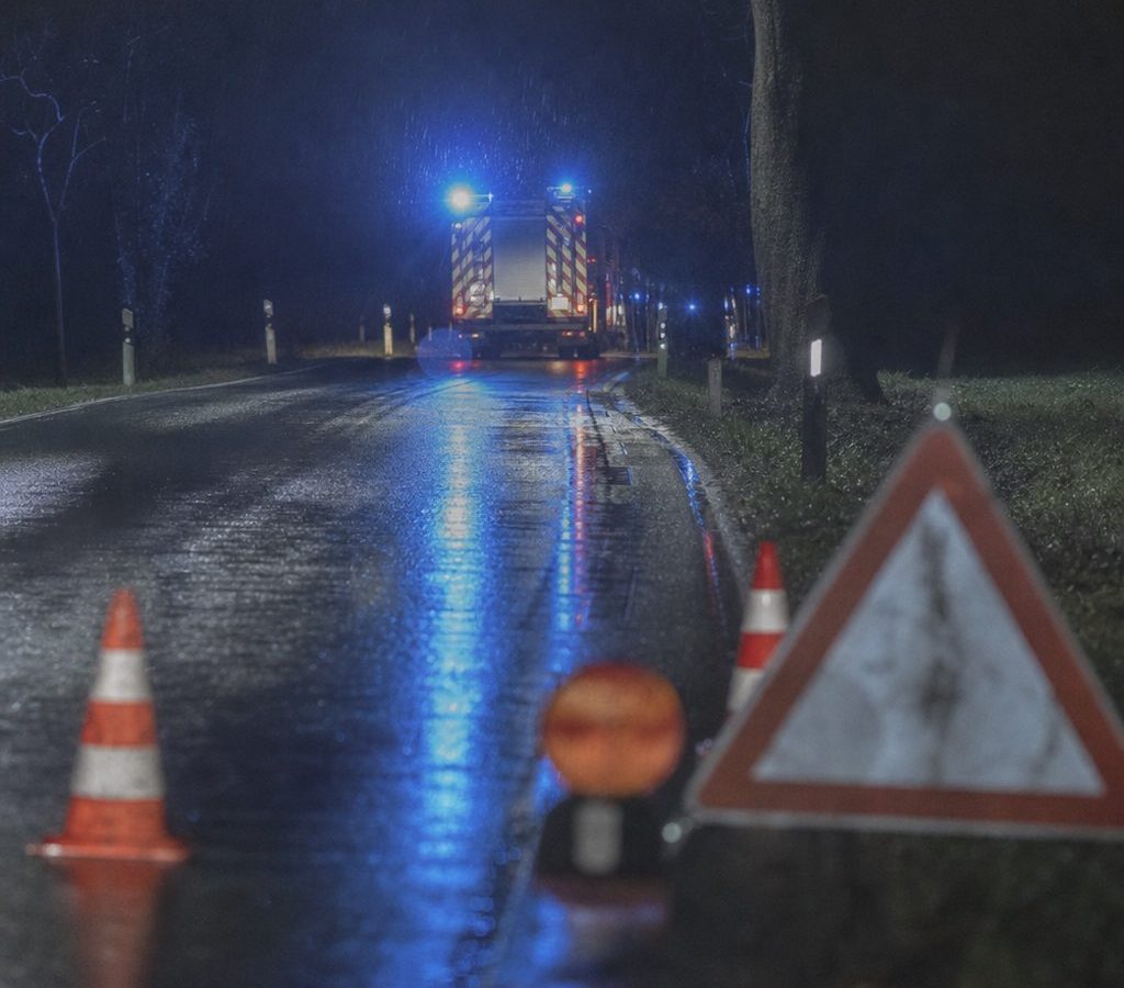 Einsatzfahrzeug mit Blaulicht bei Nacht auf einer Landstraße